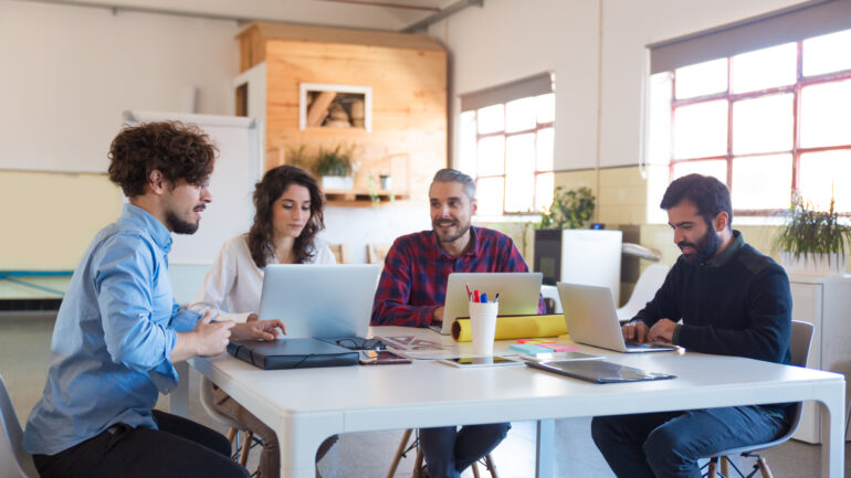 Creative group working on startup, using laptops