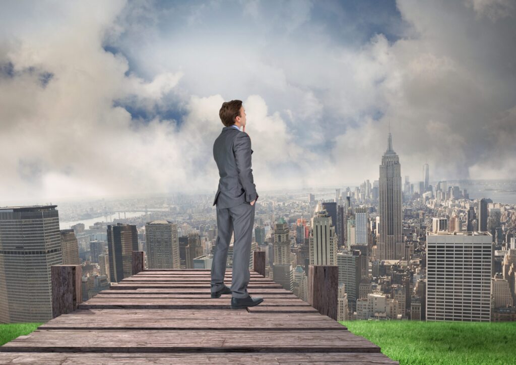 Thoughtful businessman standing on pier with city background